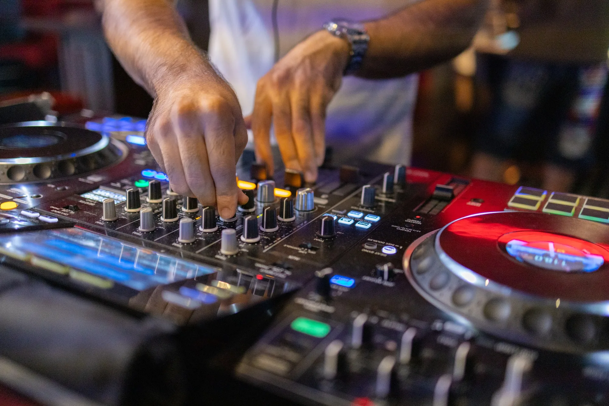 DJ's Hands Adjusting Music Mixer at Event